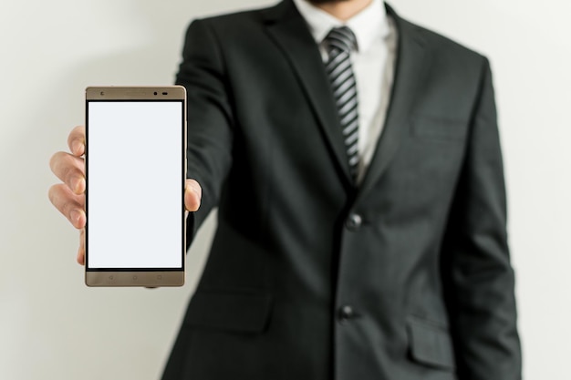 Man in a suit and tie shows the camera a tablet