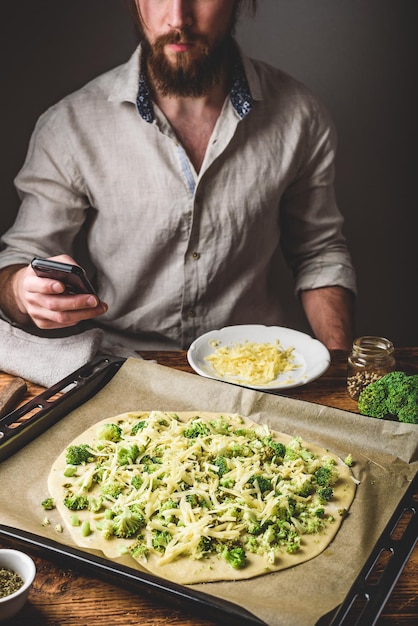 Man surfing phone while cooking