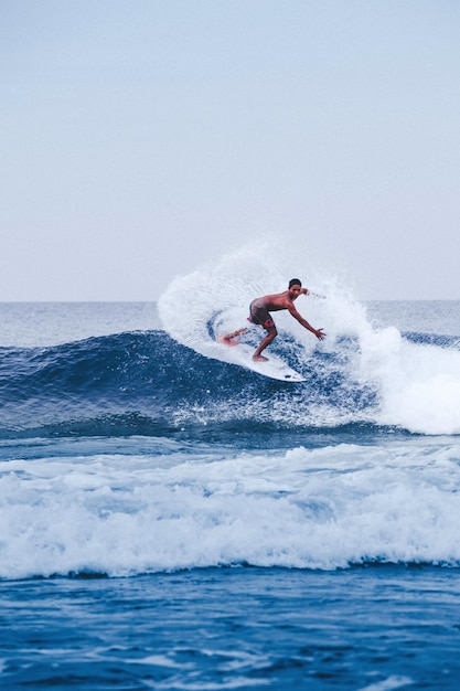 Man surfing in sea against sky