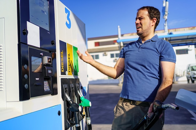 Man surprised by expensive fuel prices at a gas station