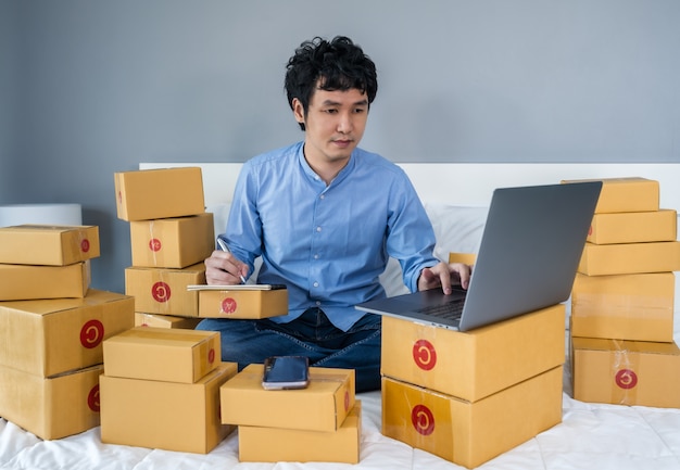 man surrounded by boxes using a laptop