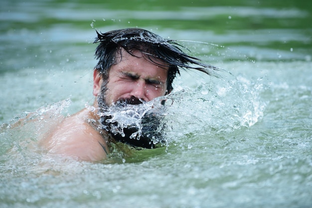 Man swimmer male swimming in water. Summer time lake. Wet hair.