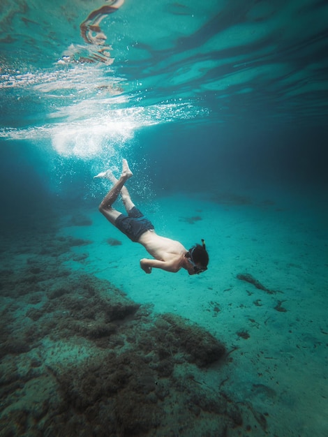 A man swimming under water with the word ocean on the bottom.