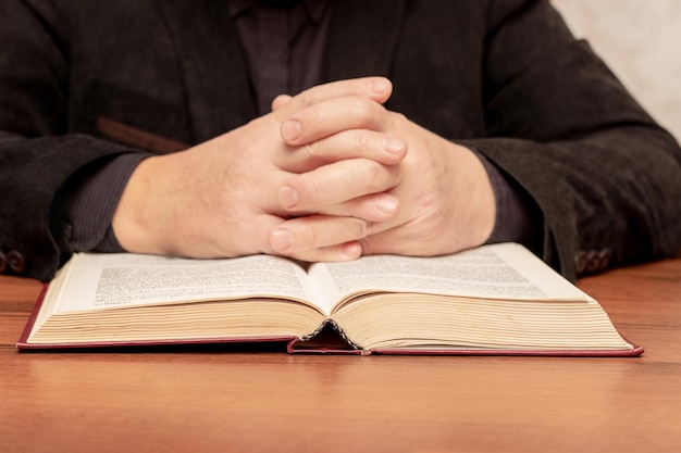 A man at the table is reading the Bible Man near the Bible during prayer