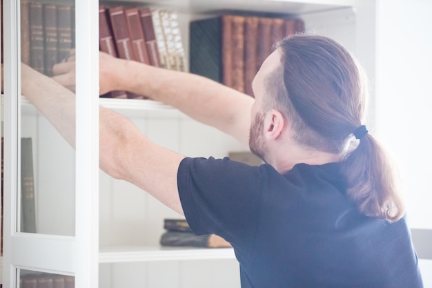 Man taking book from shelf