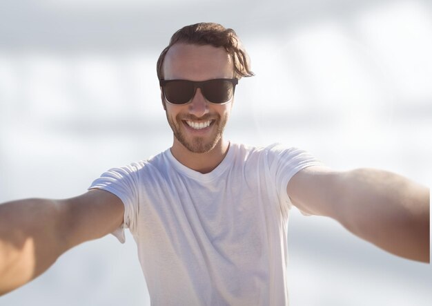 man taking casual selfie photo in front of blurred bright background