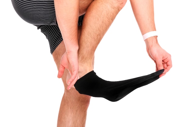 a man taking off his socks over white