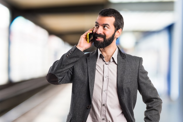 Man talking to mobile on unfocused background