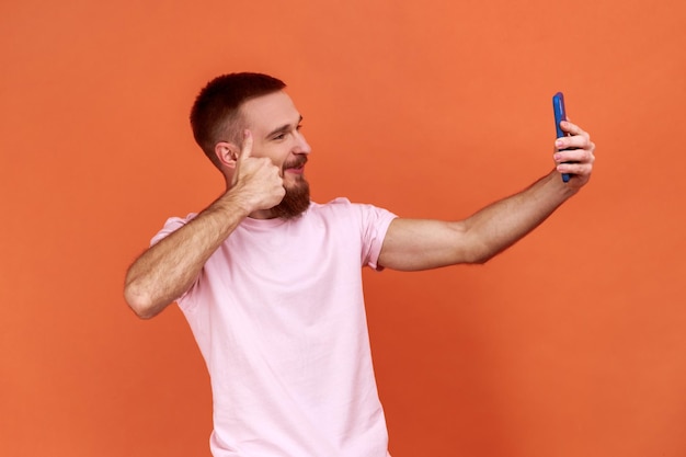 Man talking on video call and gesturing thumbs up like sign having online conversation taking selfie