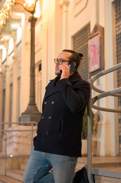 Man talks on phone on the street at night