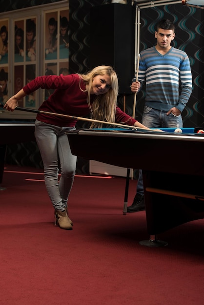 Man Teaching Woman How To Play Pool