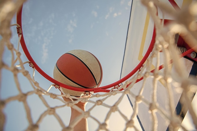 Man throwing the ball in hoop hands and basketball dunk in basket slam dunk in motion