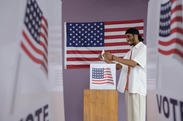 Man throwing envelope in box to vote