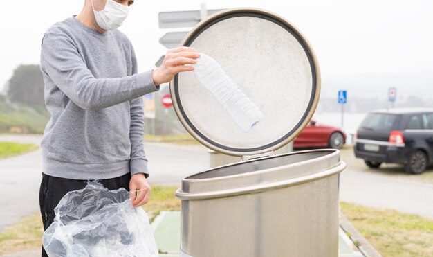 Man throwing plastic containers at plastic recycling point. 