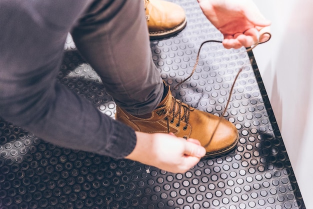 Photo man tie shoelaces on shoes fashion boots