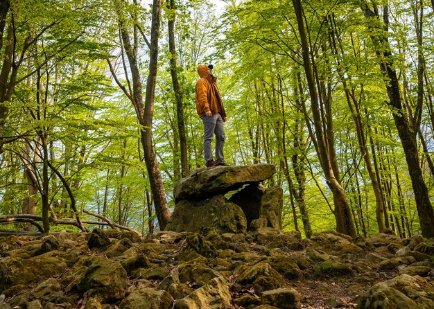 A man on top of the Aitzetako Txabala Dolmen in the Basque Country in spring Errenteria Gipuzkoa