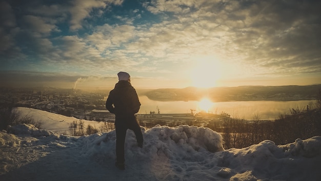 Man on the top on mountain Evening Sunset Landscape Cold Winter. 