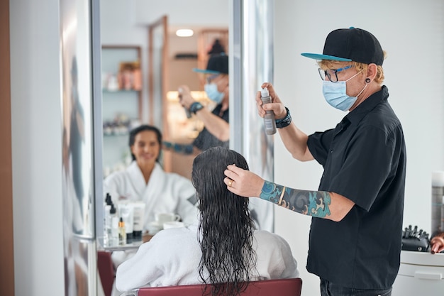 Man in a total black clothes taking care of the hair