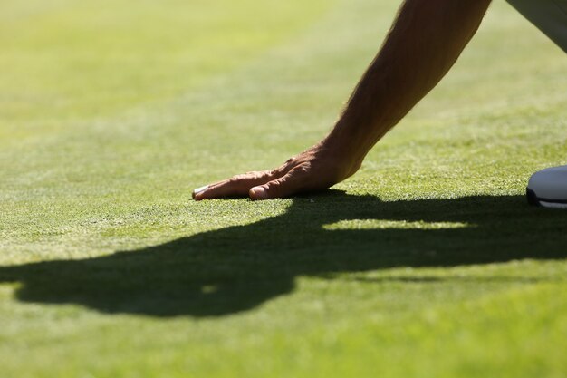 man touching the green grass