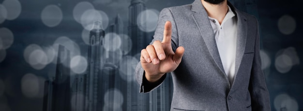 Man touching screen on the background of buildings