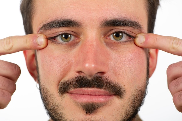 Man touching skin under eyes