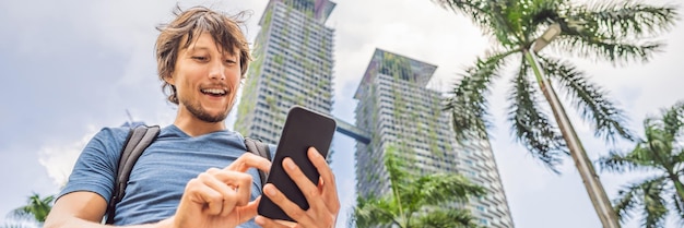 Man tourist using navigation app on the mobile phone navigation map on a smartphone in a big city