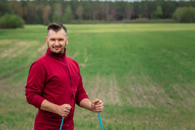 A man in a tracksuit is engaged in Nordic walking