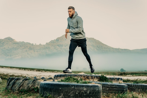 Man training outdoor with tires.Man jumping tires