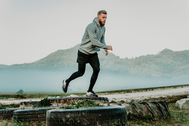 Man training outdoor with tires.Man jumping tires