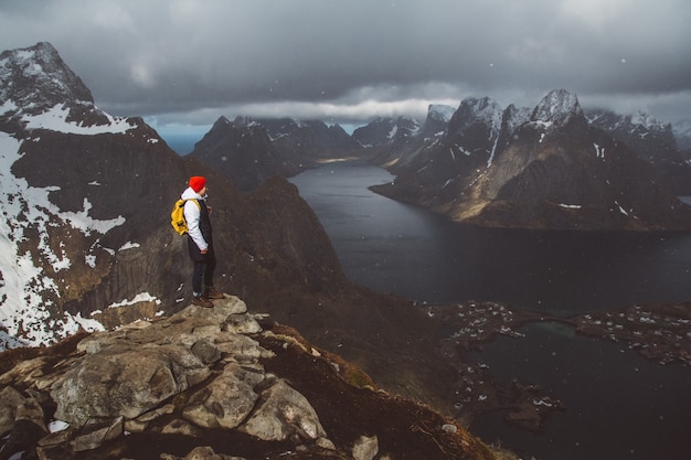 Man traveler hiking on Reinebringen mountain ridge in Norway lifestyle adventure traveling.