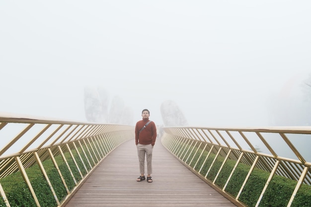 Man Traveler sightseeing Golden bridge at the top of the Ba Na Hills Landmark and popular Vietnam and Southeast Asia travel concept