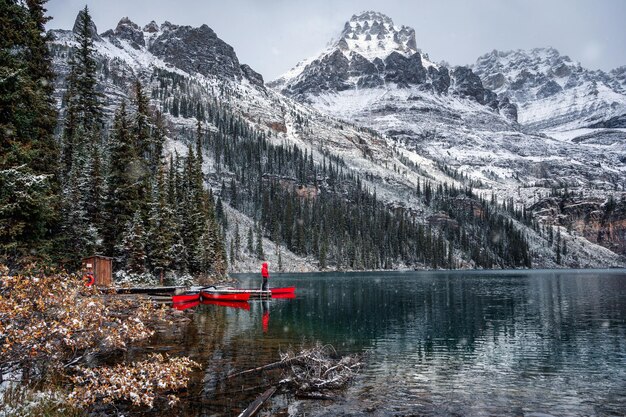 Man traveler standing on wooden pier with rocky mountains in Lake O'hara at Yoho national park, Canada