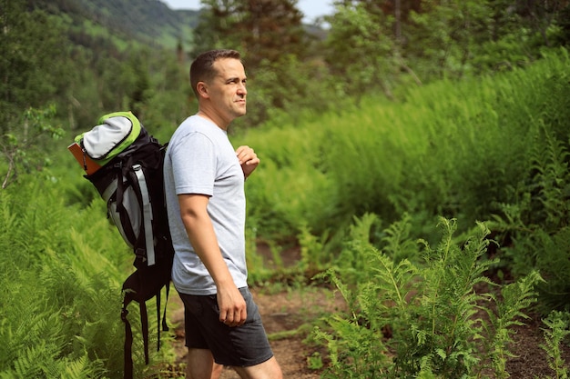 Man traveler with a backpack resting outdoors Summer holidays and lifestyle hiking concept