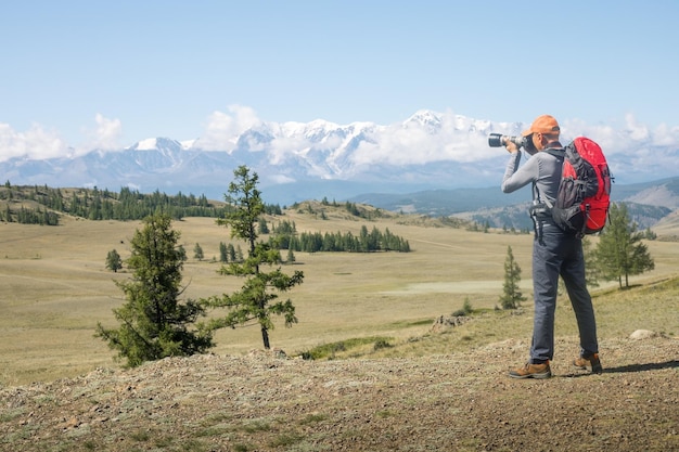 Man traveling with backpack and camera hiking in mountains Travel Lifestyle success concept adventure active vacations