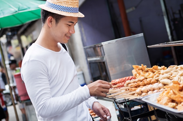 man traveller enjoying asian thailand street food