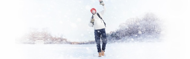 A man travels with a backpack. Winter hike in the forest. Tourist on a walk in the winter in the park.