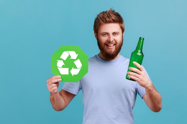 Man in Tshirt holding glass bottle and recycling green symbol sorting his rubbish saving ecology