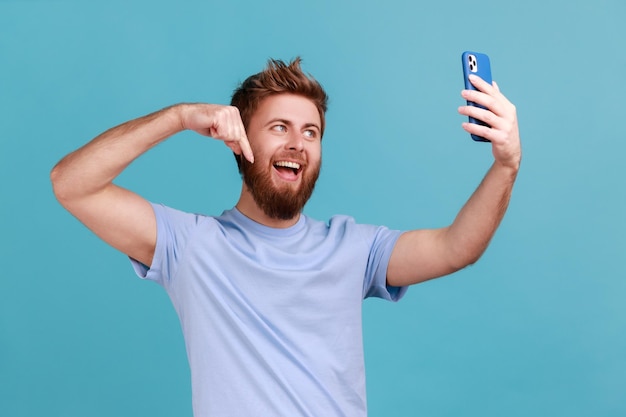 Man in Tshirt smiling and pointing down streaming to subs having positive conversation online