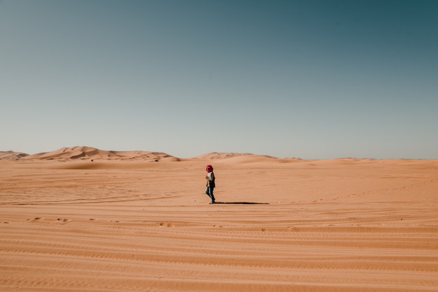 Man in turban walking alone in the desert