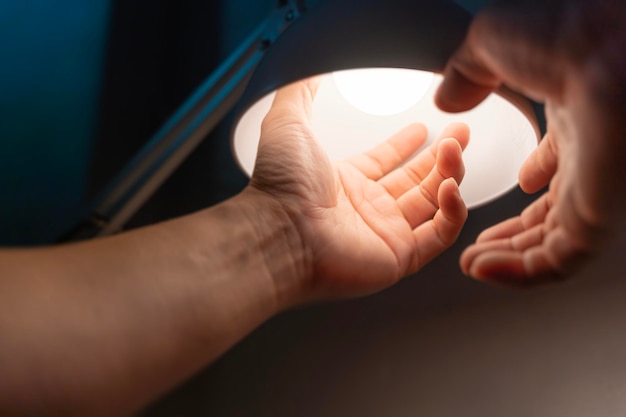 Man turning into a light bulb LED at the desk lamp electric change warm light at home