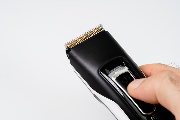 A man turns on the power of a cordless hair clipper