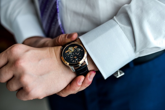 Man in a tux fixing his cufflink