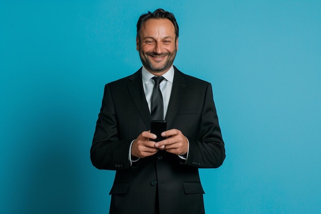 Photo a man in a tuxedo holds a phone in his hands