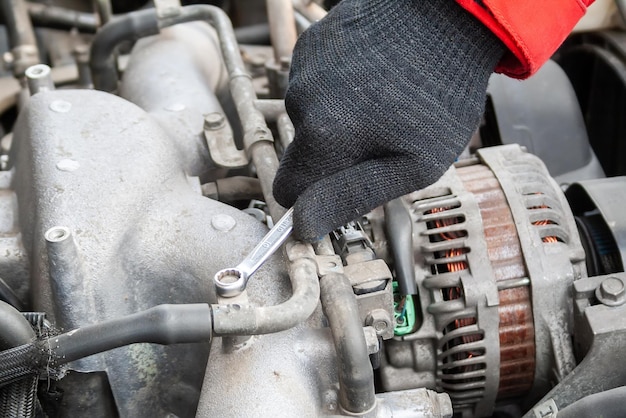 Man twists the nut under the open hood of a Flatfour boxer car engine