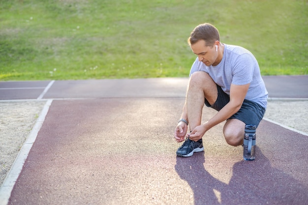 Man tying shoelaces on sneakers before training