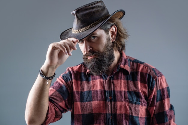 Man unshaven cowboys. American cowboy. Leather Cowboy Hat. Portrait young man 