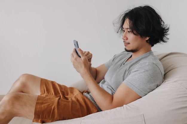 Man use smartphone while sit and relax on bean bag sofa