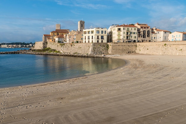 A man uses a metal detector on a beach overlooking Antibes Cote d'Azur France