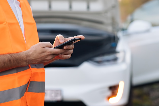 Photo the man uses the phone after the electric car has broken down