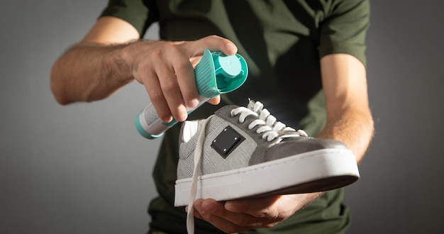 Man using antibacterial spray against unpleasant odors